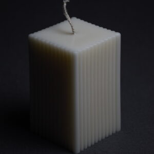 Close-up of The Plinth unscented soy wax candle, square shape, on dark background